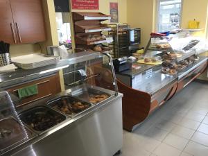 a bakery counter with a bunch of donuts on at Kálvária Apartman in Baja