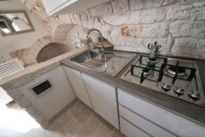 a kitchen with a sink and a stove at Dimora Lumi in Locorotondo +14 photos