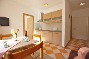 a kitchen and dining room with a table and chairs at Apartman Simona in Fažana +6 photos