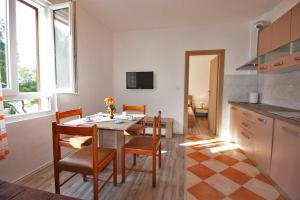 a kitchen and dining room with a table and chairs at Apartman Simona in Fažana