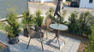 a patio with a table and two chairs and an umbrella at FeAp Brombachsee - Sonnentag Ost in Röttenbach