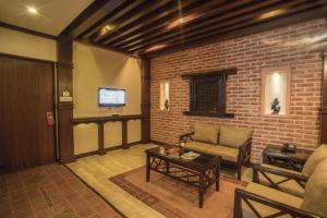 a living room with a couch and a brick wall at Hotel Marshyangdi in Kathmandu