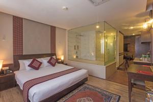 a bedroom with a large bed and a bathroom at Hotel Marshyangdi in Kathmandu