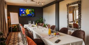 a long table in a restaurant with a tv on the wall at Hotel Restaurant Au Riesling in Zellenberg