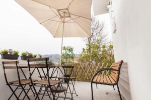 a patio with a table and chairs and an umbrella at Quinta da Salada - Alojamento Local Douro in Peso da Régua