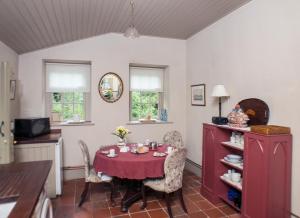 uma sala de jantar com uma mesa vermelha e cadeiras em Batty Langley Lodge em Leixlip