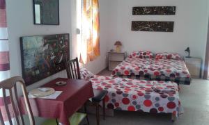 a bedroom with two beds and a table and a table and chairs at Danijela Apartmani in Čanj