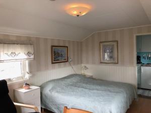 1 dormitorio pequeño con 1 cama y cocina en Lillstugan, en Kärradal