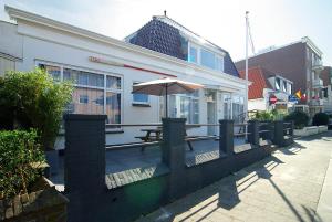 a patio with a table and an umbrella in front of a building at Hotel Zand in Zandvoort