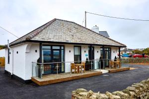 a small white building with a porch and chairs at Trearddur Bay Hotel in Trearddur