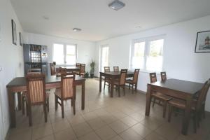 a dining room with tables and chairs and windows at Penny Pension in Groß Sisbeck