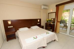 a bedroom with a large bed with flowers on it at Hotel Viana in Loutra Edipsou +29 photos