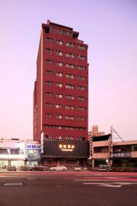 台中的住宿－薆悅酒店台中館，前面有一条街道的红色高楼