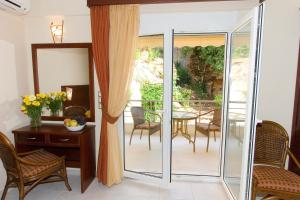 a room with a balcony with a table and chairs at Hotel Viana in Loutra Edipsou
