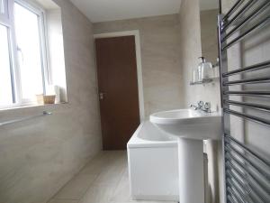 a white bathroom with a sink and a mirror at Greyhound Inn in Winterborne Kingston