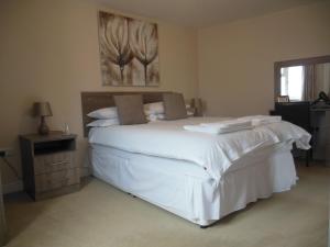 a bedroom with a bed and a dresser at Greyhound Inn in Winterborne Kingston