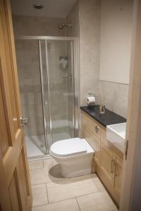 a bathroom with a shower and a toilet and a sink at Apartment E in Aberdeen