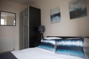 a bedroom with a bed with a blue pillow on it at Apartment E in Aberdeen