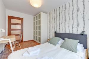 グダニスクにあるGdańsk Comfort Apartments Wejheraのベッドルーム1室(ベッド1台、テーブル、デスク付)