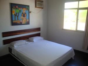 um quarto com uma cama branca e uma janela em Hotel Pousada Terras do Sem Fim em Ilhéus
