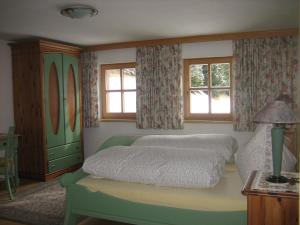 um quarto com uma cama, uma cómoda e janelas em Ferienhaus Ebnerle em Heiligenblut