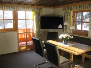 uma sala de jantar com uma mesa de madeira e cadeiras em Ferienhaus Ebnerle em Heiligenblut