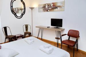 a room with two beds and a desk with a television at Bella Trastevere in Rome