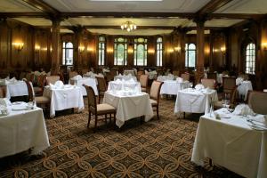 un comedor con mesas y sillas blancas en White Swan Hotel, en Alnwick