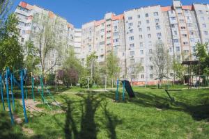 a playground in a park with tall buildings at Clean and comfortable apartments on Karl Marx street in Tiraspol