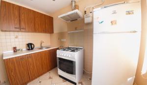 La cuisine est équipée d'une cuisinière blanche et d'un réfrigérateur. dans l'établissement Clean and comfortable apartments on Karl Marx street, à Tiraspol