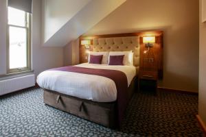 a bedroom with a large bed in a room at Angels Hotel in Uddingston