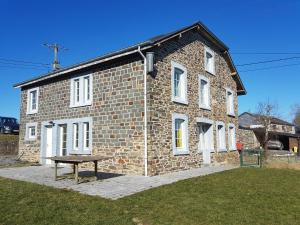 a brick building with a picnic table in front of it at Le Clos de Rosa in La Roche-en-Ardenne