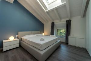 1 dormitorio con 1 cama grande y tragaluz en Residenza Cece' en Lecco