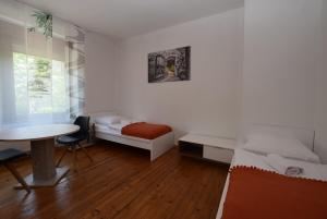 um pequeno quarto com uma cama e uma mesa em Apartment Ostendplatz em Stuttgart