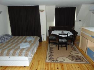 um quarto com uma mesa e uma cama e uma mesa e cadeiras em Burgas Central Aleksandrovska em Burgas