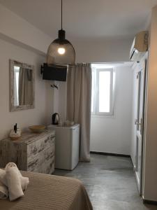 um quarto com uma cama, um lavatório e uma janela em Ioanna's House em Míconos