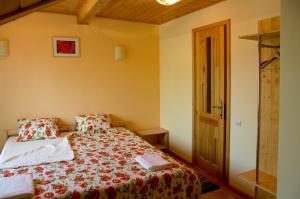 a small bedroom with a bed with a floral bedspread at Guest House Magones in Preiļi