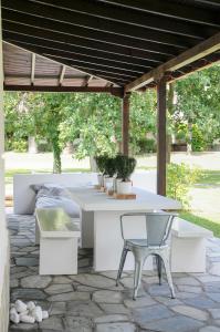a patio with a table and chairs under a pergola at #Luxlikehome - The Seascape Villa in Skála Foúrkas