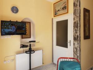 Habitación con puerta y TV en la pared en Hostel Beko en Valjevo