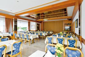 a banquet hall with white tables and blue chairs at Hotel Gasthof Rössle in Rottenburg