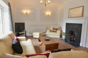 a living room with a couch and a fireplace at Clarendon House in Shanklin
