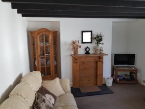 a living room with a couch and a television at The Cottage in Probus