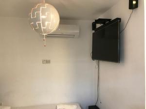 a room with a flat screen tv and a lamp at Luxury Studio Ayia Napa Center in Ayia Napa