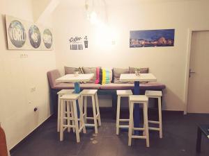 two tables and stools in a room with a couch at White Rabbit Hostel in Hvar