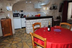 een keuken met een tafel met een fles wijn erop bij Gite " Le Troglo des 3 Châteaux " in Amboise