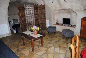 a living room with a table and a fireplace at Gite " Le Troglo des 3 Châteaux " in Amboise