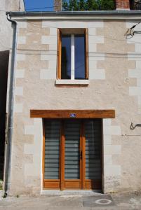 アンボワーズにあるGite " Le Troglo des 3 Châteaux "の二つのドアと窓のある建物
