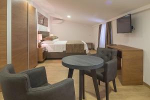 ein Zimmer mit einem Tisch und Stühlen und einem Bett in der Unterkunft Villa Mandalinic in Omiš