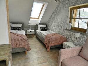 シュクラルスカ・ポレンバにあるApartamenty EverySky - Osiedle Podgórze 1Eのベッドルーム1室(ベッド2台、ソファ付)