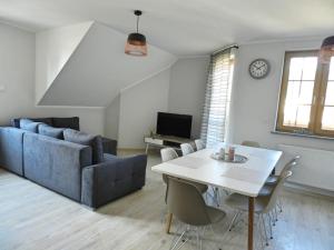 een woonkamer met een bank en een tafel bij Apartamenty EverySky - Osiedle Podgórze 1E in Szklarska Poręba